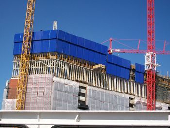 Low angle view of construction site against clear blue sky