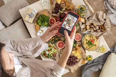 High angle view of woman photographing food