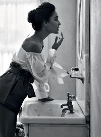 Side view of young woman standing in bathroom