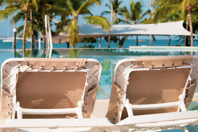 Lounge chairs by swimming pool at beach