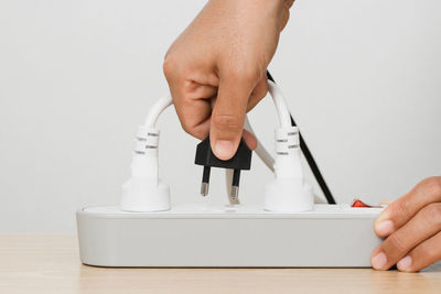 Cropped hands of woman using calculator on table