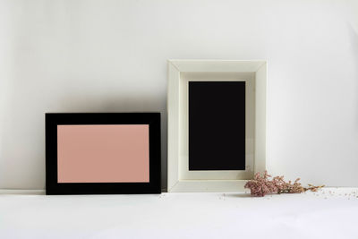 Close-up of blank picture frames against white wall