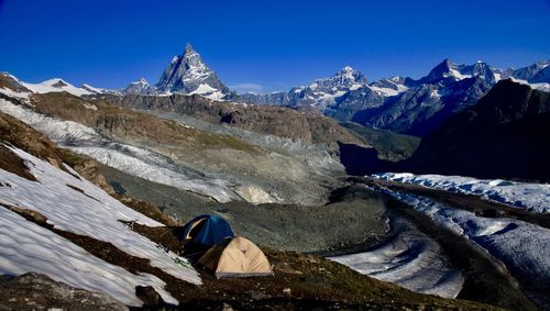 Scenic view of snowcapped mountains against blue sky