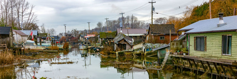 Panoramic view of canal amidst buildings against sky