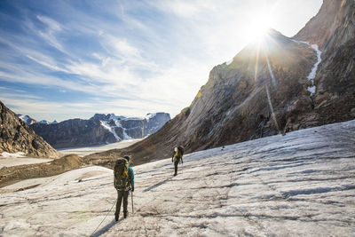 People on snowcapped mountain against sky