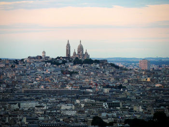 Mid distant view of basilique du sacre coeur against sky during sunset