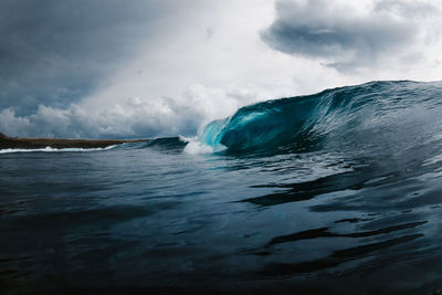 Waves splashing in sea against sky