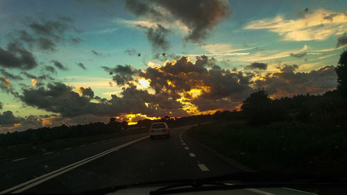 Car on road against sky during sunset