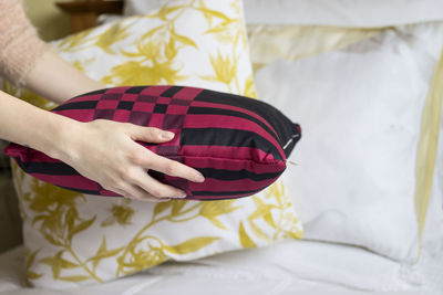 Midsection of woman holding umbrella on bed