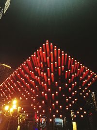 Low angle view of illuminated buildings against sky at night