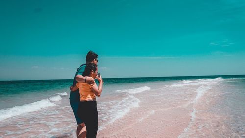 Man standing at beach against sky