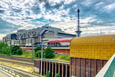 Buildings in city against cloudy sky