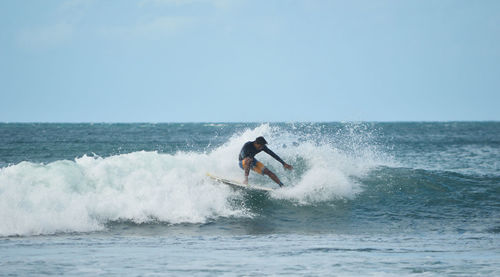 Man surfing in sea against clear sky