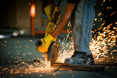 Low section of man working on metal at workshop