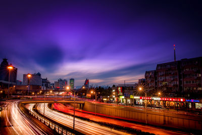 Light trails on road along buildings at night