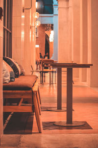 View of empty chairs and tables in illuminated building