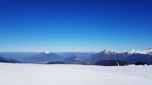 Scenic view of snowcapped mountains against clear blue sky