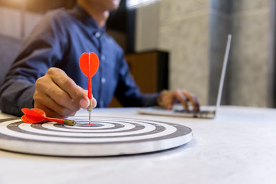 Close-up of man playing with eyeglasses on table