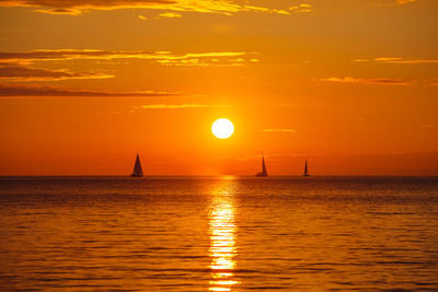 Scenic view of sea against dramatic sky during sunset