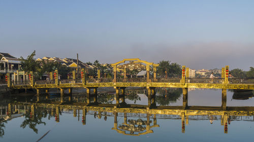 Reflection of built structure in river against sky