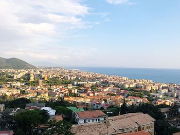 High angle view of townscape by sea against sky