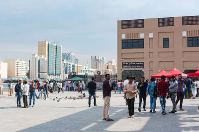 People walking on street against buildings in city