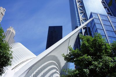 Low angle view of modern buildings against blue sky