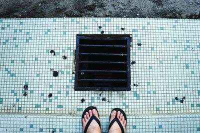 Low section of people standing on tiled floor