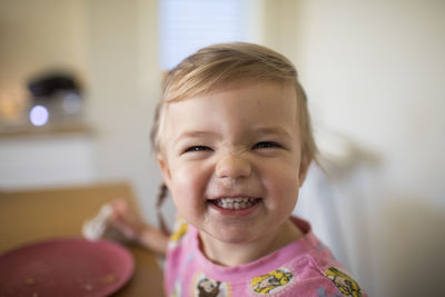 Portrait of cute girl smiling at mealtime.