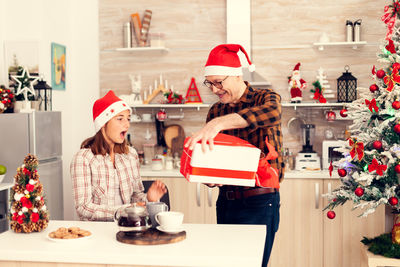 Rear view of woman holding christmas tree