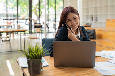 Young woman using laptop at table