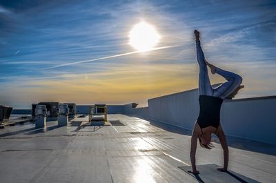 Full length of woman on road against sky during sunset