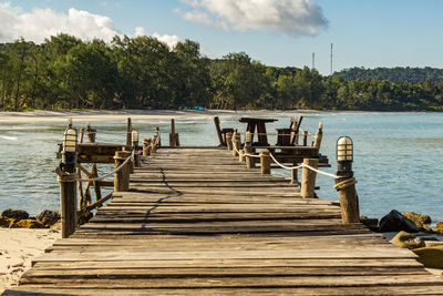 Wooden jetty on pier over lake against sky