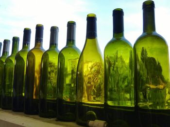 Close-up of empty wine bottles on window sill