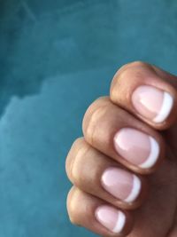 Cropped hand of woman against swimming pool