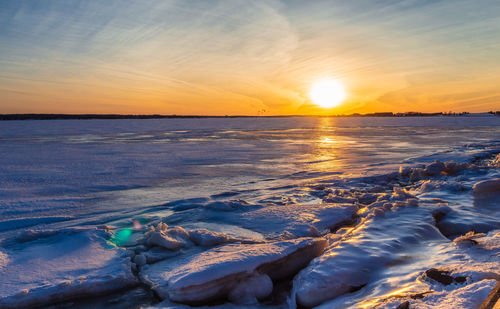 Scenic view of frozen sea against sky during sunset