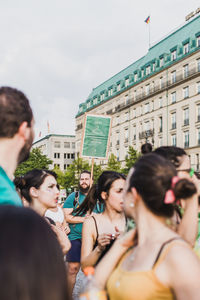 Group of people in city against sky