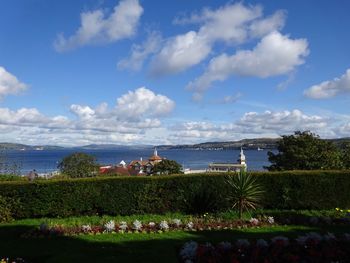 Scenic view of sea by buildings against sky