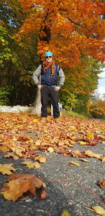 Man standing by leaves during autumn