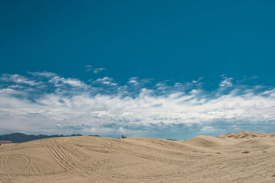 Scenic view of desert against blue sky