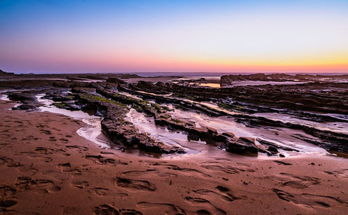 Scenic view of beach against sky during sunset