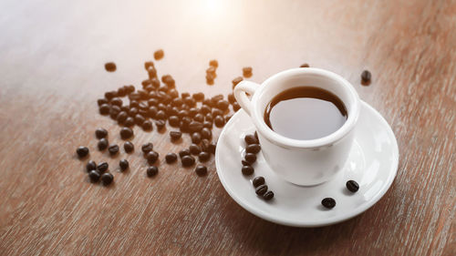 Black coffee in a white cup on an old wooden table.