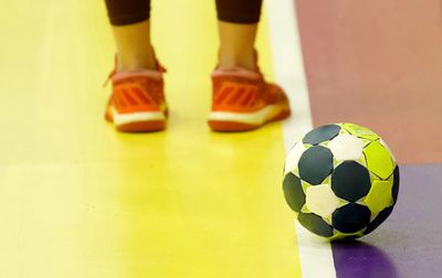 Low section of person standing on soccer ball