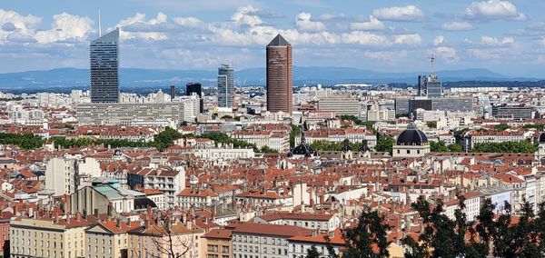 Aerial view of buildings in city against sky