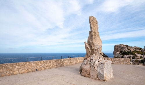 Rock on beach against sky