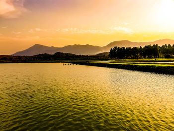 Scenic view of lake against sky during sunset