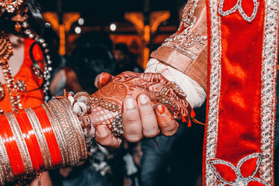 Midsection of newlywed couple holding hands