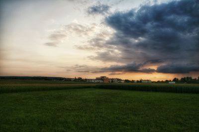 Scenic view of grassy field against cloudy sky