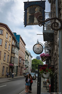 People on street amidst buildings in city