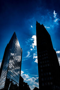 Low angle view of modern buildings against blue sky